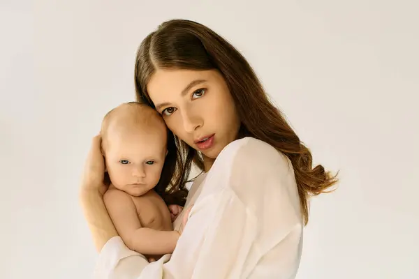 Young mother lovingly cradles her baby, showcasing tender moments of early motherhood. — Stock Photo