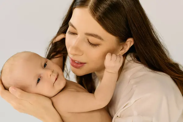 Una giovane madre tiene stretta la sua bambina sorridente, condividendo un momento d'amore che incarna la gioia della famiglia.. — Foto stock