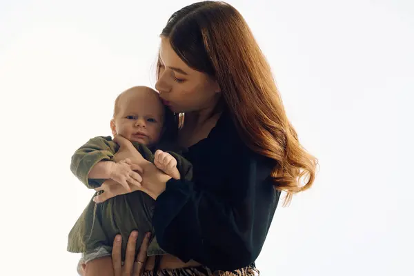 Una madre bacia amorevolmente il suo bambino, catturando l'essenza della famiglia e della connessione. — Foto stock