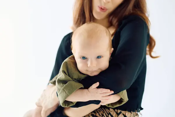 Una madre sostiene amorosamente a su bebé, celebrando su vínculo especial. - foto de stock