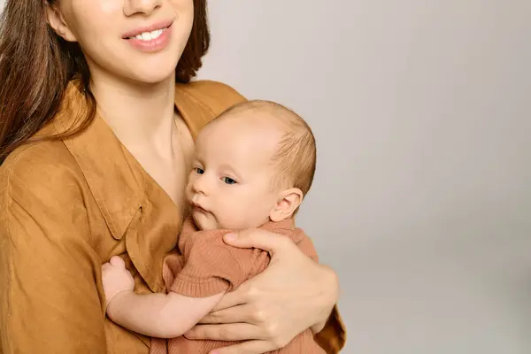 Une mère joyeuse tient son bébé près de lui, rayonnant de chaleur et d'amour en ce moment tendre. — Photo de stock