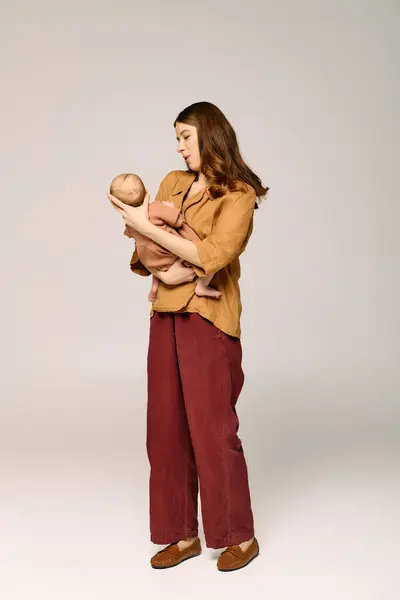 Una giovane madre tiene teneramente il suo bambino, condividendo un momento speciale in un ambiente moderno. — Foto stock