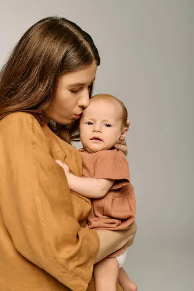 Una madre devota bacia la fronte dei suoi piccoli figli, mostrando un momento speciale di connessione. — Foto stock