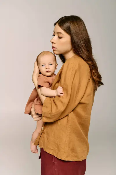 Une jeune mère montre son lien avec son bébé, incarnant l'amour et la joie de la parentalité. — Photo de stock