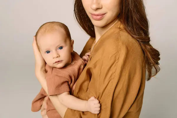 A young mother lovingly holds her child close, filled with warmth in a cozy atmosphere. — Stock Photo