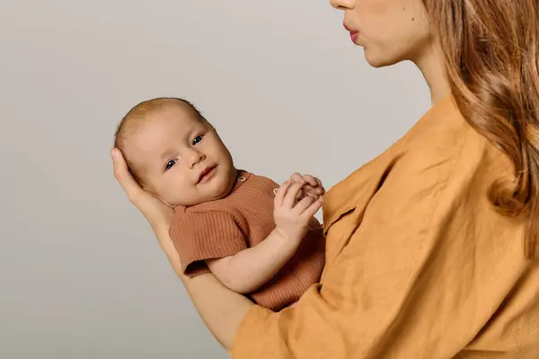 A young mother cradles her child, expressing the warmth of parenthood and connection. — Stock Photo