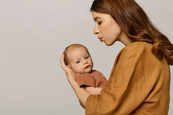Une belle jeune mère regarde avec amour son petit enfant tout en partageant un moment tendre ensemble. — Photo de stock