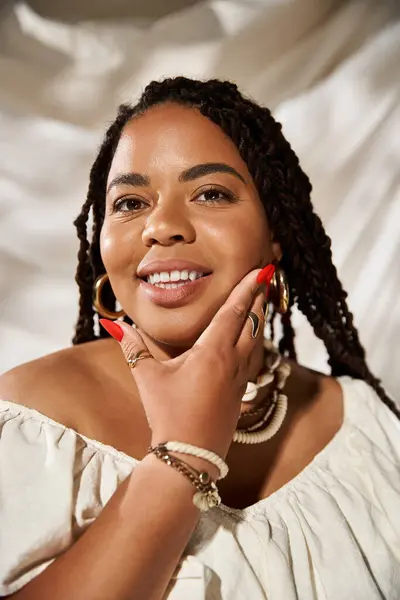 A joyful African American woman with braids enjoys a summery, green setting. — Stock Photo