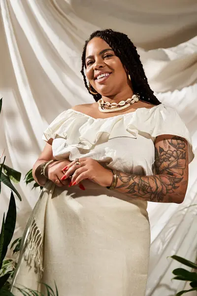 Uma mulher alegre com tranças vestidas com uma bela roupa de verão posa entre plantas verdes. — Fotografia de Stock