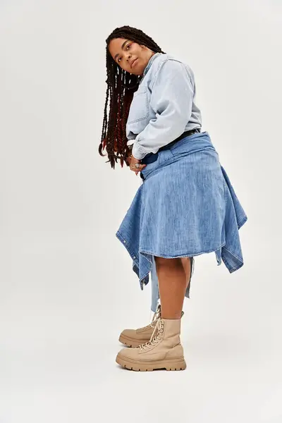 A confident African American woman showcases her style in a denim ensemble while posing gracefully. — Stock Photo