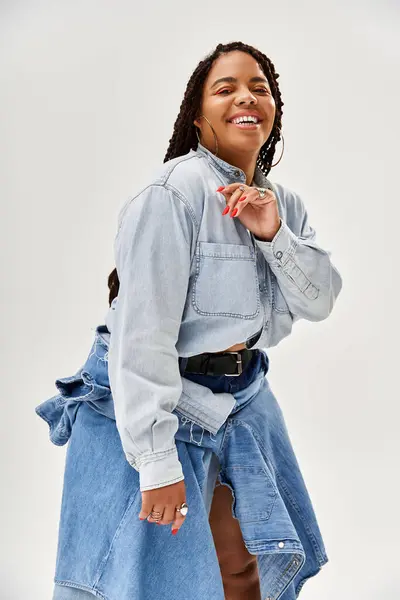 A joyful African American woman in braids and denim radiates happiness. — Stock Photo