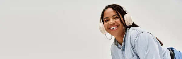 A joyful African American woman with braids smiles while posing in a stylish denim outfit, banner — Stock Photo