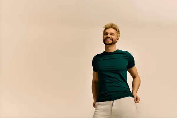 Handsome young man smiling joyfully while relaxing in a simple indoor environment. — Stock Photo
