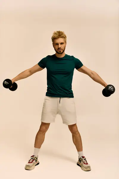 Hübscher Mann zeigt Stärke und Hingabe beim Heben von Gewichten, wobei er sich auf Fitness konzentriert. — Stockfoto