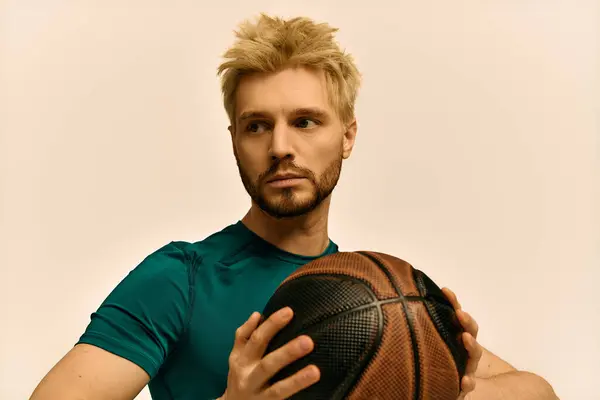 Giovane atletico tiene una pallacanestro, concentrato e pronto per una sessione sportiva emozionante. — Foto stock