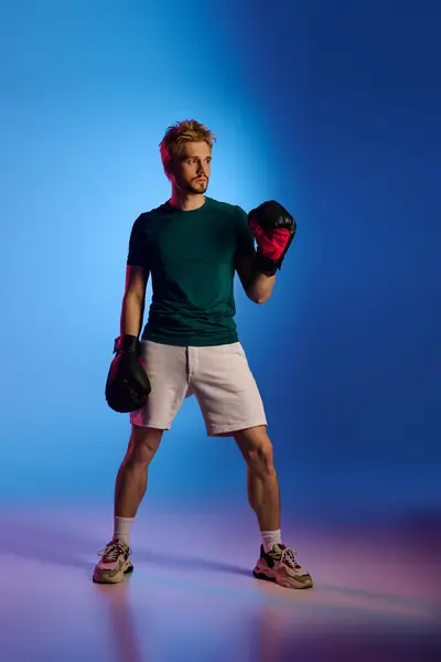Uomo sportivo in abito elegante si prepara per la boxe, evidenziando determinazione e fiducia. — Foto stock