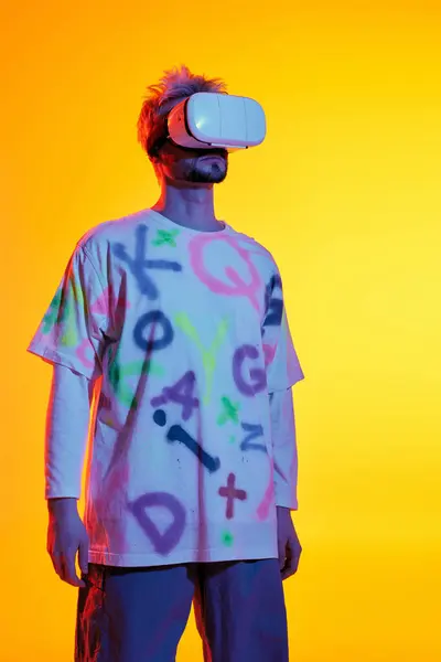 Bello giovane uomo si erge con fiducia indossando un auricolare realtà virtuale, immerso nella sua esperienza. — Foto stock