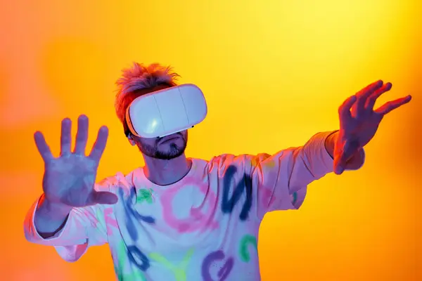 In a vibrant setting, a handsome young man immerses himself in virtual reality. — Stock Photo