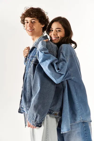 Stylish couple cuddles in matching denim, radiating joy and love. — Stock Photo