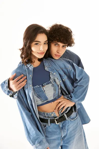 A young couple embraces each other while displaying trendy denim outfits, radiating love and joy. — Stock Photo