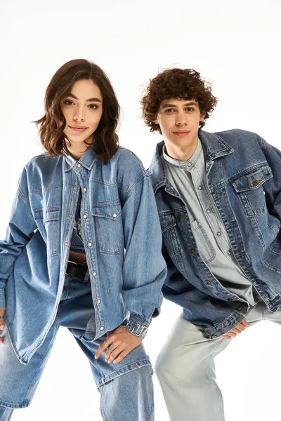 Fashionable young couple joyfully poses together in trendy denim outfits. — Stock Photo