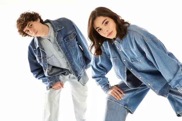 A young couple stands confidently in fashionable denim outfits, embodying love and style together. — Stock Photo