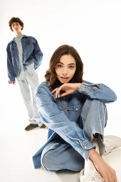 A young couple showcases their trendy outfits while exuding romance and connection in a studio. — Stock Photo