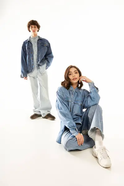 Young couple shows love in stylish denim against a minimalist backdrop. — Stock Photo