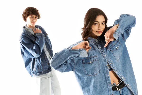 A fashionable young couple radiates love and trendiness while posing in oversized denim jackets. — Stock Photo
