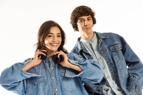 Pareja cariñosa muestra sus trajes elegantes, mientras que felizmente usando auriculares, exudando romance. - foto de stock