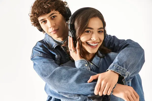 A pair of young lovers confidently enjoy listening to music while embracing each other. — Stock Photo