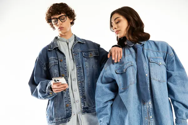 A young couple showcases their love and style while enjoying each others company in trendy denim. — Stock Photo