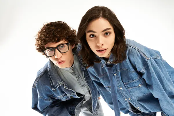 Jovem casal posa juntos, exalando amor e estilo em roupas de ganga combinando. — Fotografia de Stock