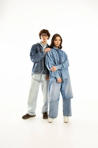 A young couple in trendy denim outfits stands close, showing their love and style. — Stock Photo