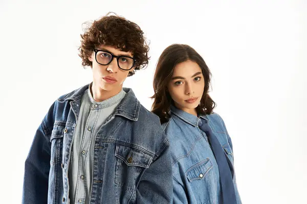 A young couple stands closely together, exuding love and style in trendy denim outfits. — Stock Photo