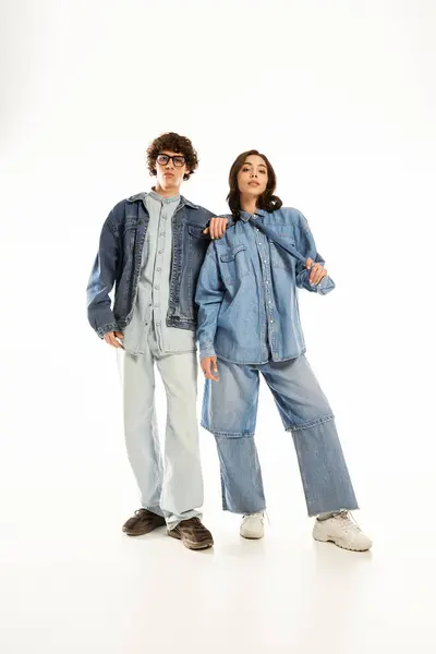 Young couple poses confidently against a clean white backdrop, radiating love and style. — Stock Photo