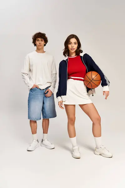 A stylish young couple holds a basketball, radiating romance and confidence. — Stock Photo