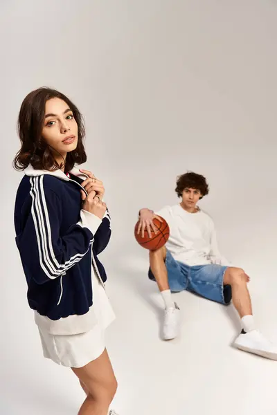 A young couple in trendy sportswear shows love and connection as they pose creatively. — Stock Photo