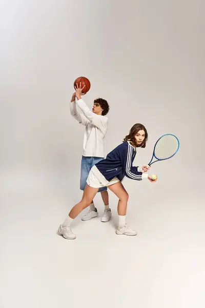 Elegante giovane coppia godendo di un momento di divertimento giocando a basket e tennis insieme — Foto stock