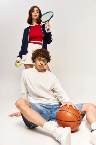 Stylish couple expresses playful affection while showcasing trendy sports attire with accessories. — Stock Photo
