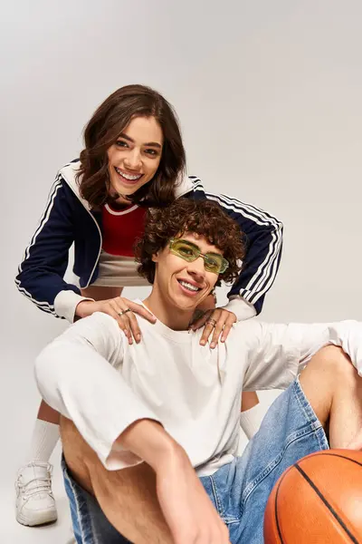 Stylish young couple shares a joyful moment with a basketball, radiating love and happiness. — Stock Photo
