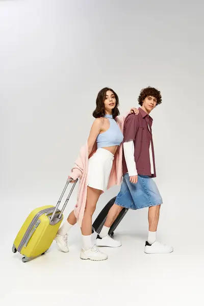 A young couple exuding love and style, ready to travel with their vibrant suitcases. — Stock Photo