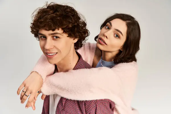 Una joven pareja irradia amor y estilo mientras se abraza juguetonamente en un ambiente contemporáneo. - foto de stock