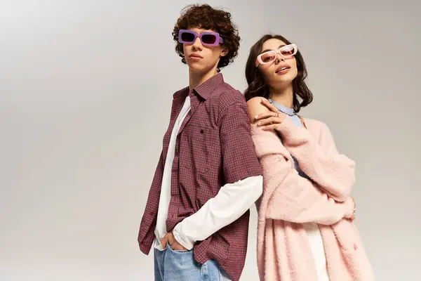 Um jovem casal exalando confiança, vestido com roupas da moda e óculos de sol elegantes, irradiando amor. — Fotografia de Stock