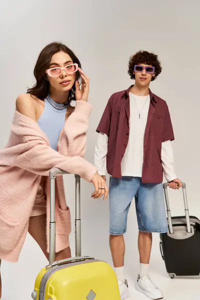A fashionable young couple stands together, luggage in hand, exuding love and confidence. — Stock Photo