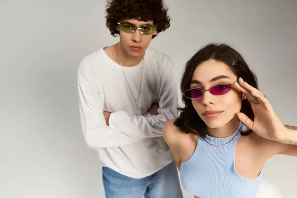 Um jovem casal na moda transpira amor e confiança enquanto posando com óculos de sol na moda. — Fotografia de Stock