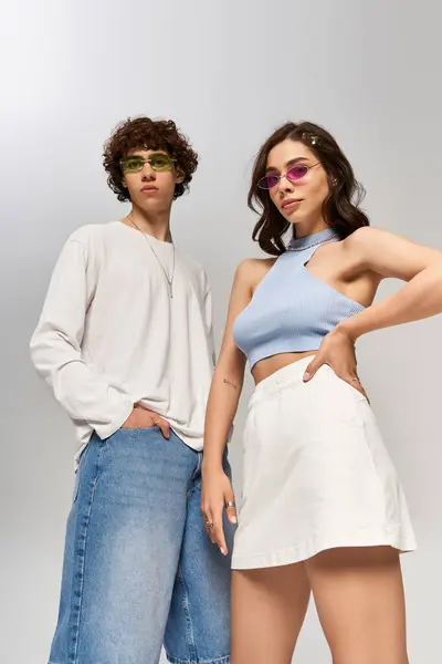 Pareja de moda posa con confianza, mostrando trajes elegantes y accesorios con alegría. - foto de stock