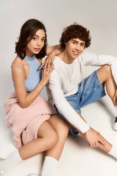 A loving couple showcases their trendy style while sitting together, radiating joy and affection. — Stock Photo