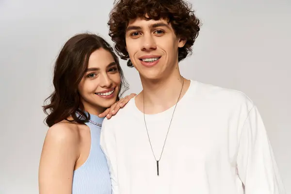 A fashionable young couple smiles warmly at the camera, radiating love and joy together. — Stock Photo