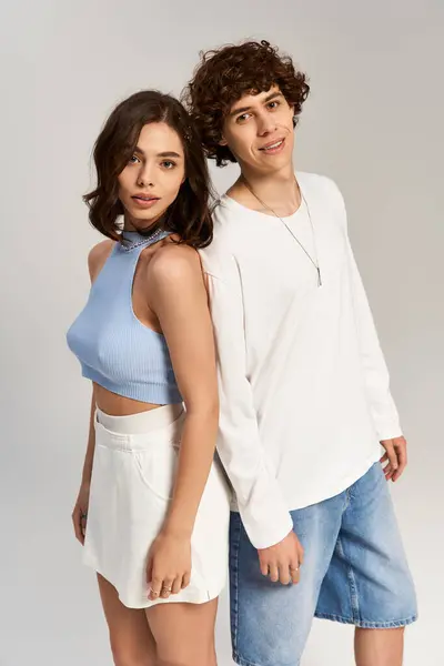 Stylish young man and woman pose together, radiating love and fashion in a minimalist setting. — Stock Photo